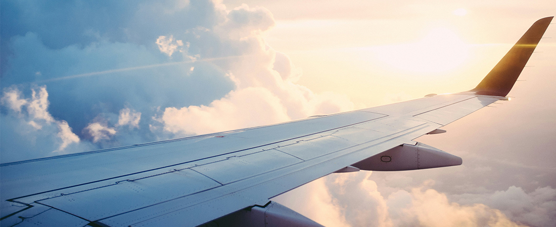Avión volando sobre nubes iluminadas por el atardecer